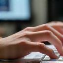Hands working on a computer keyboard.